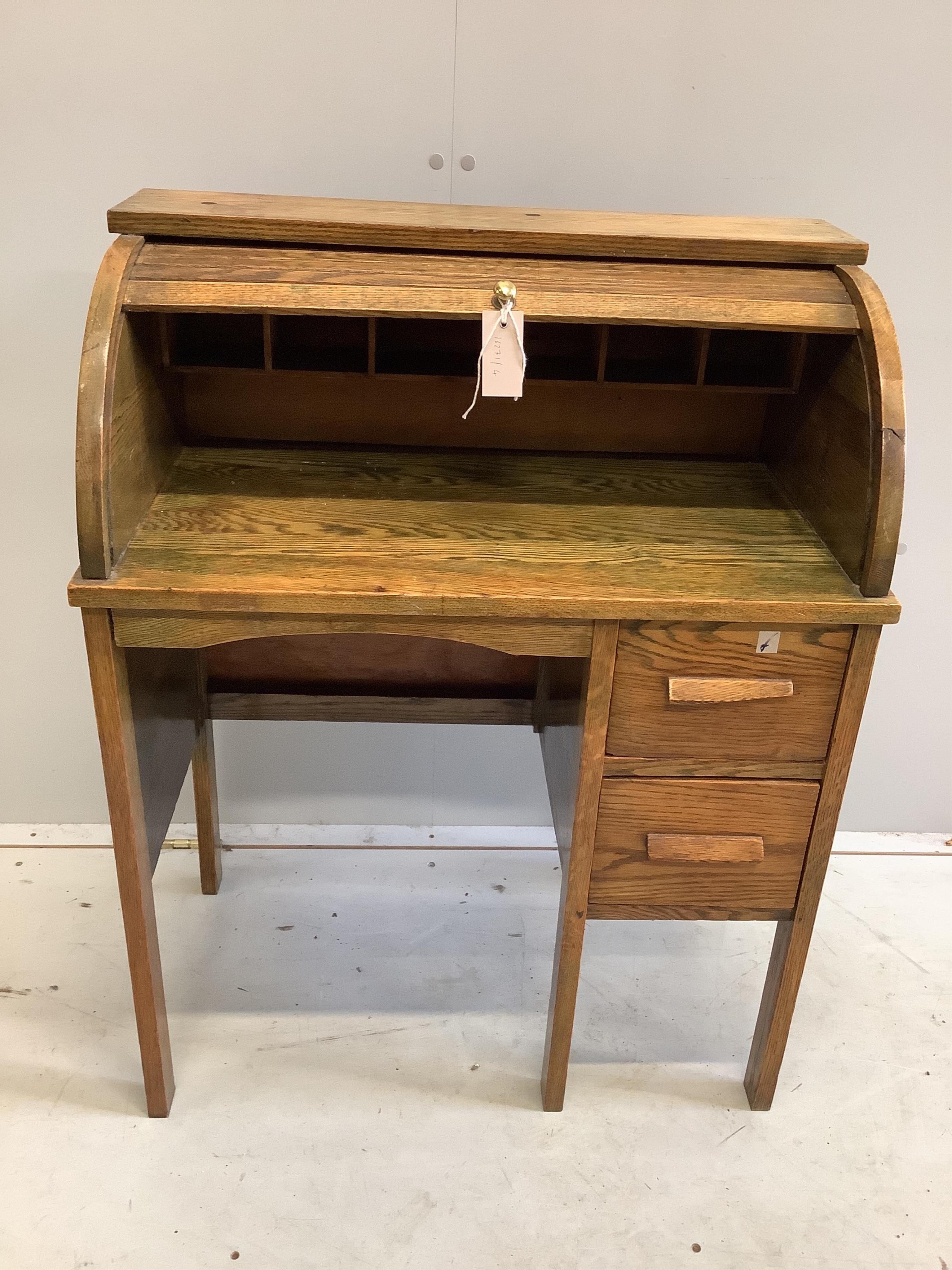 A small early 20th century oak roll top tambour shutter writing desk, width 68cm, depth 38cm, height 87cm. Condition - fair